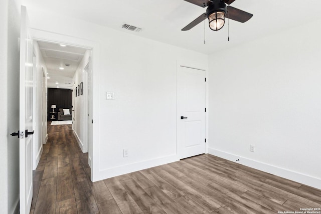 spare room with baseboards, visible vents, ceiling fan, and wood finished floors