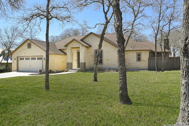 french country inspired facade featuring driveway, stone siding, fence, a front yard, and a garage