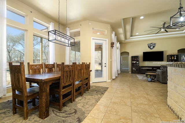 dining room with light tile patterned floors, a ceiling fan, a tray ceiling, recessed lighting, and arched walkways