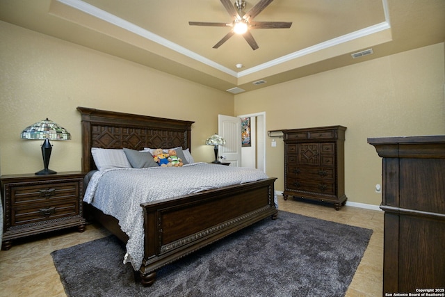 bedroom featuring baseboards, visible vents, a tray ceiling, ornamental molding, and ceiling fan