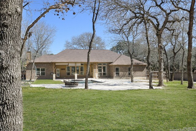 561 Jacobs Ln, La Vernia, TX 78121 - rear view of house featuring a patio, brick siding, and a chimney