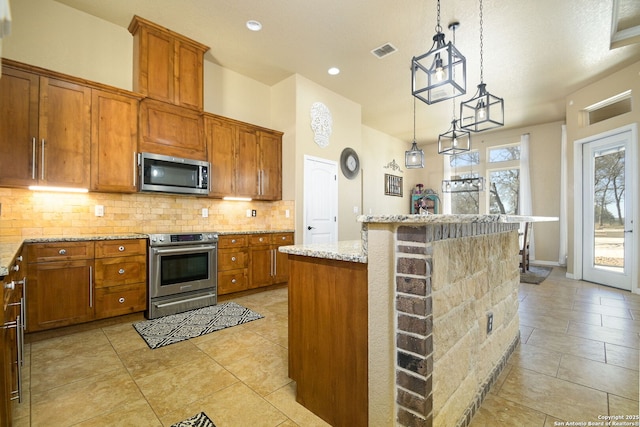 kitchen featuring tasteful backsplash, brown cabinetry, visible vents, and stainless steel appliances