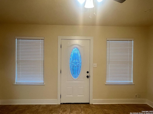 entryway featuring ceiling fan and baseboards