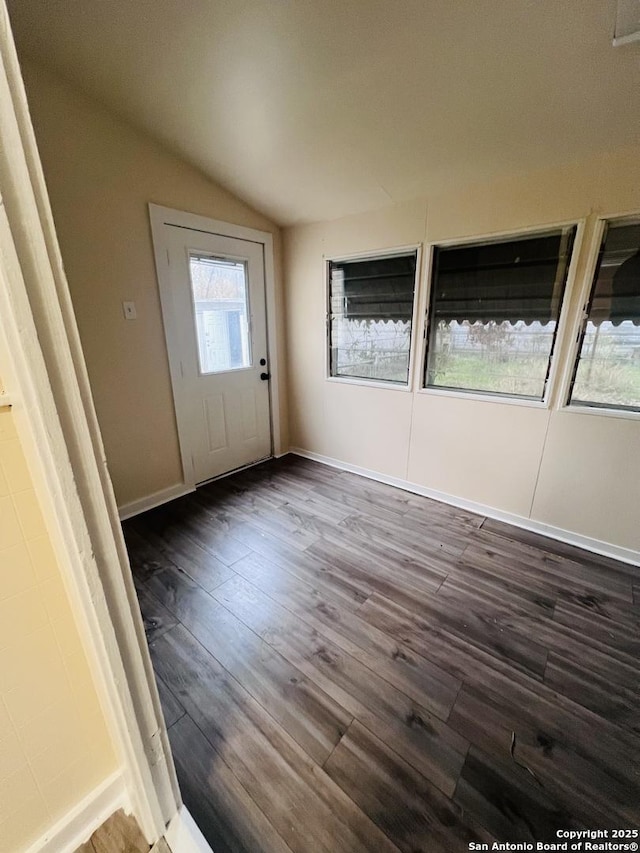 foyer featuring dark wood-style floors, baseboards, and vaulted ceiling