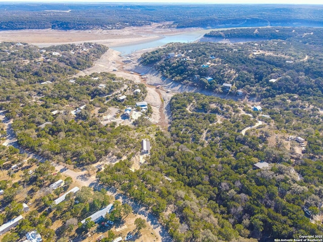 aerial view with a water view and a wooded view