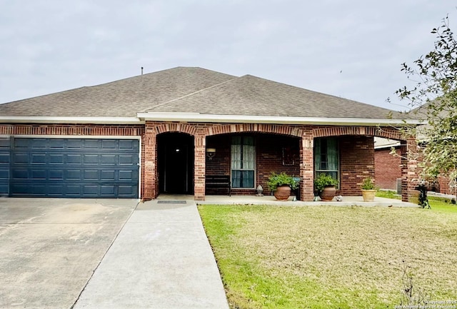 ranch-style house featuring a shingled roof, brick siding, a garage, and a front lawn