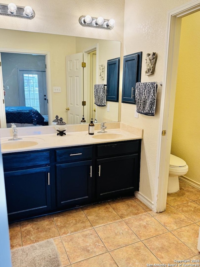 full bathroom featuring double vanity, ensuite bath, tile patterned flooring, and a sink