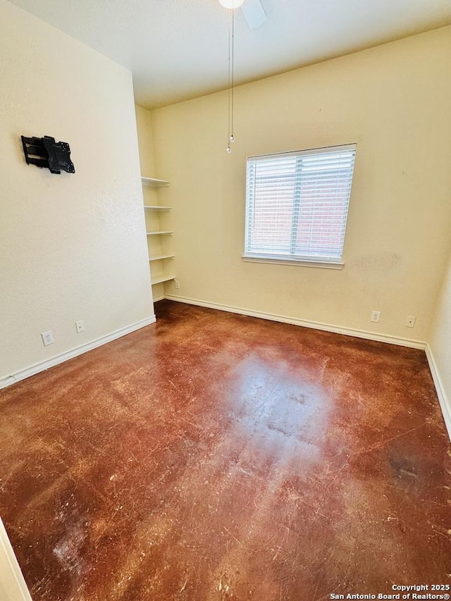 empty room featuring finished concrete flooring and baseboards