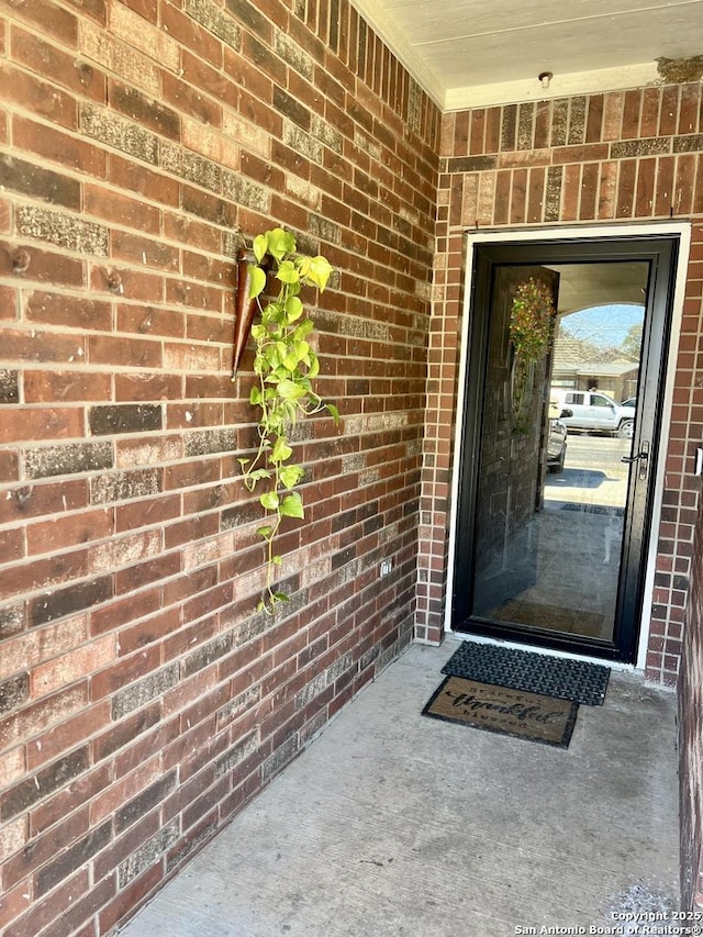 view of exterior entry with brick siding