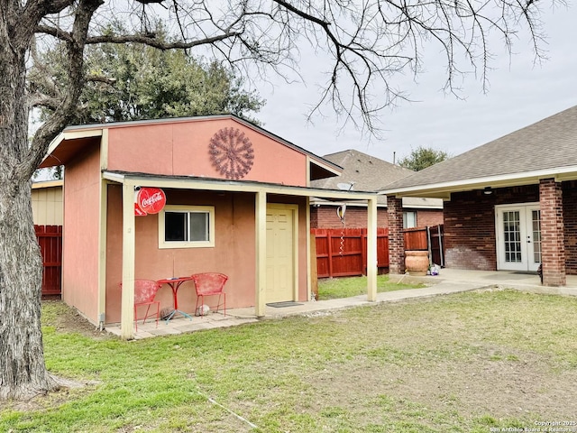 view of outbuilding with french doors and fence