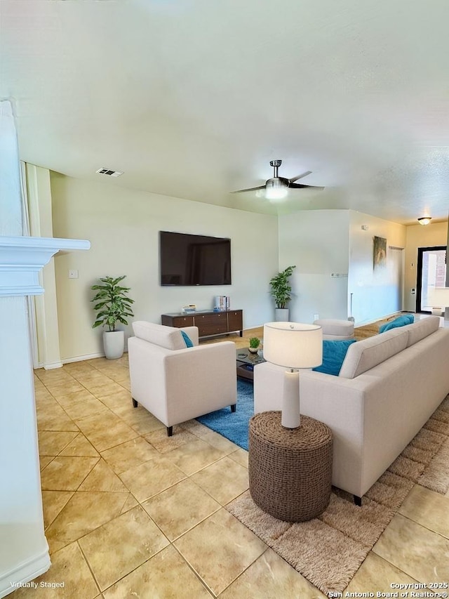 living room with ceiling fan, visible vents, and light tile patterned flooring