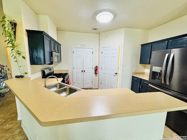 kitchen featuring stainless steel appliances, light countertops, visible vents, a sink, and a peninsula