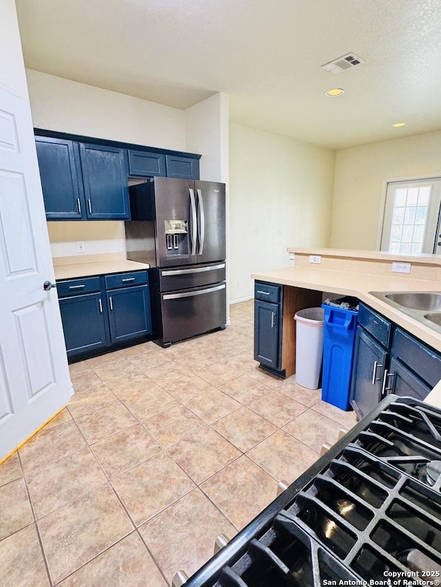 kitchen featuring blue cabinets, visible vents, light countertops, and stainless steel fridge with ice dispenser