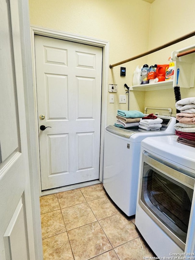 washroom with washing machine and dryer, laundry area, and light tile patterned floors