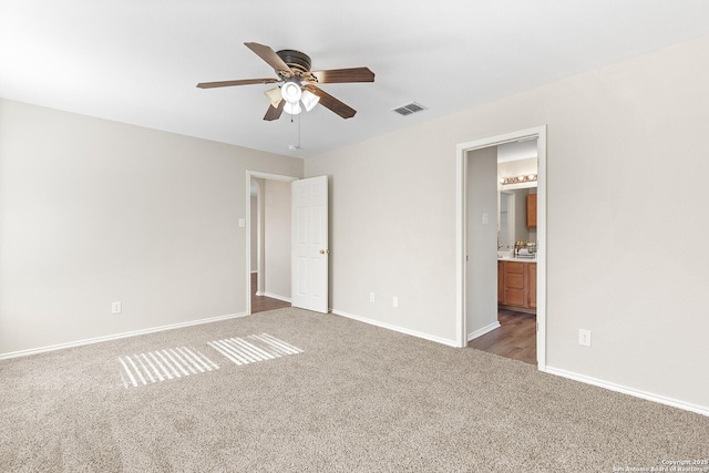 unfurnished bedroom featuring baseboards, visible vents, a ceiling fan, connected bathroom, and carpet flooring