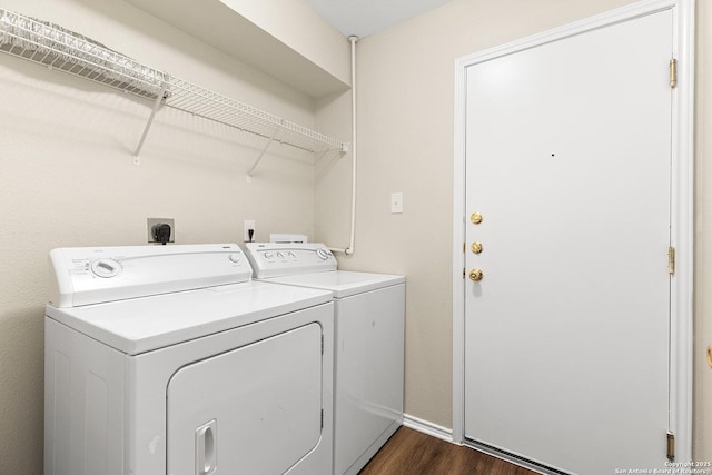 laundry room with dark wood-style floors, laundry area, washing machine and clothes dryer, and baseboards