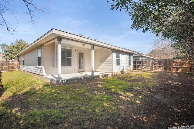 rear view of house with a patio area, a fenced backyard, and a yard