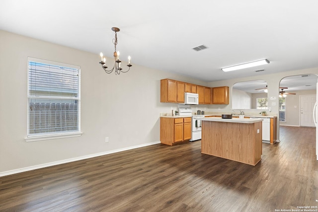 kitchen featuring white appliances, visible vents, arched walkways, dark wood-style floors, and light countertops