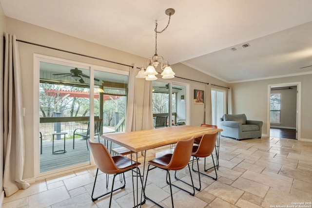 dining room featuring stone tile floors, visible vents, ornamental molding, baseboards, and ceiling fan with notable chandelier