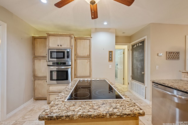 kitchen featuring ceiling fan, baseboards, appliances with stainless steel finishes, light stone countertops, and light brown cabinetry