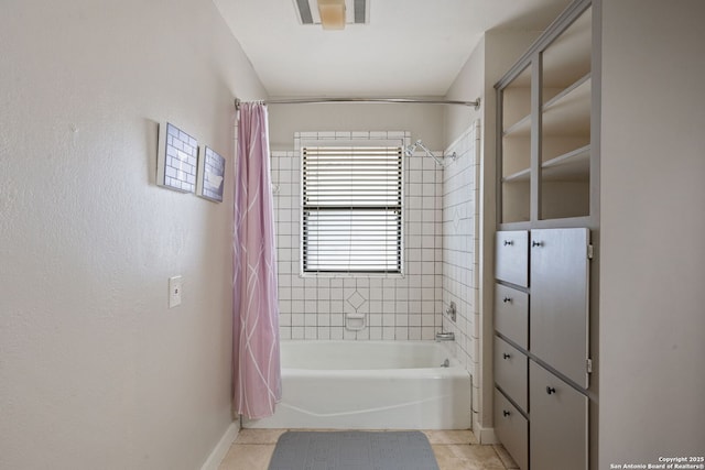 bathroom featuring tile patterned floors, visible vents, baseboards, and shower / bath combo with shower curtain