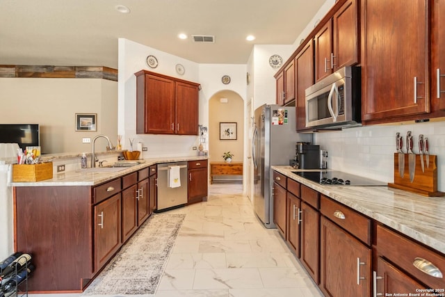 kitchen featuring arched walkways, stainless steel appliances, a peninsula, a sink, and marble finish floor