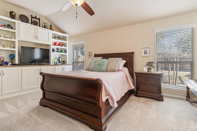 bedroom with light colored carpet, vaulted ceiling, and ceiling fan