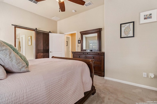 carpeted bedroom featuring a ceiling fan, a barn door, visible vents, and baseboards