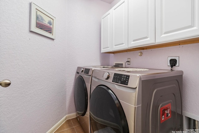 clothes washing area featuring cabinet space, a textured wall, independent washer and dryer, baseboards, and tile patterned floors