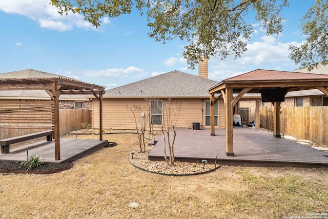 back of property with a gazebo, fence private yard, a wooden deck, and a pergola