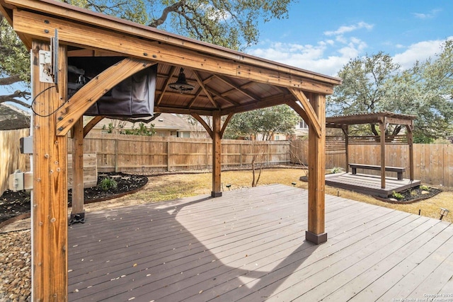 wooden deck featuring a fenced backyard and a gazebo