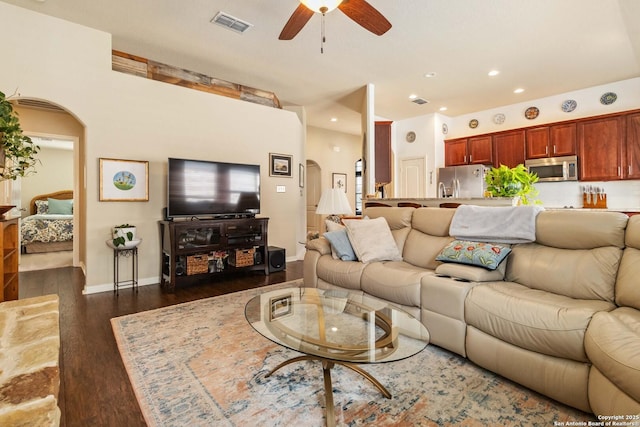 living area with arched walkways, dark wood finished floors, recessed lighting, visible vents, and ceiling fan