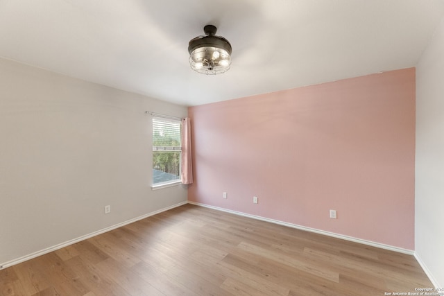 empty room featuring light wood finished floors and baseboards