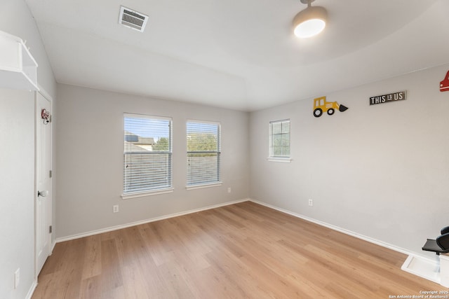 unfurnished room featuring light wood finished floors, baseboards, and visible vents