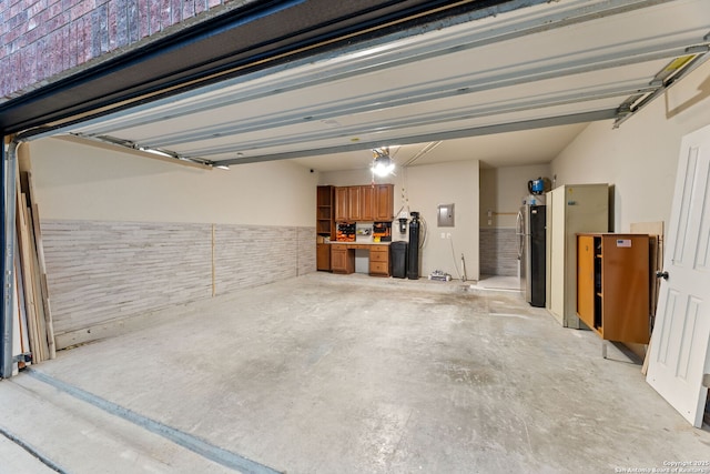 garage with freestanding refrigerator and electric panel