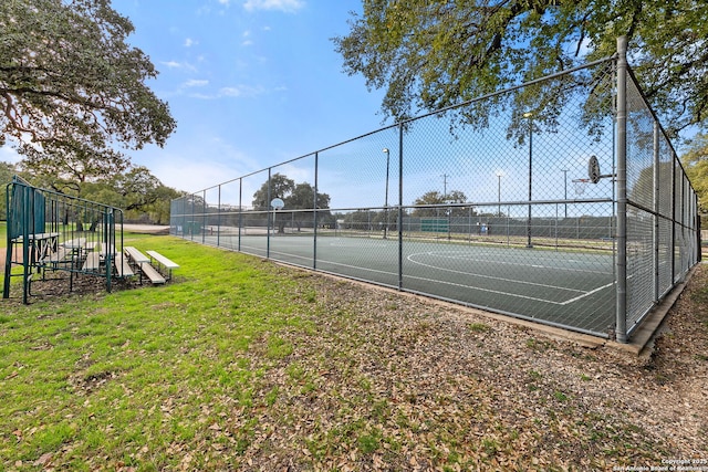 view of sport court with community basketball court, fence, and a lawn