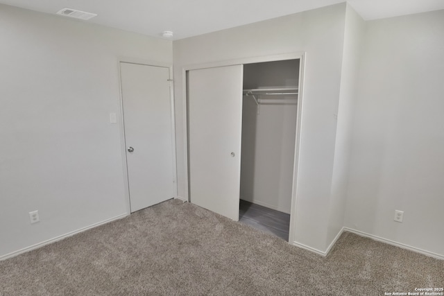 unfurnished bedroom featuring carpet floors, a closet, and visible vents