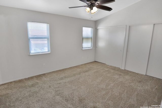 unfurnished bedroom with vaulted ceiling, carpet floors, two closets, and a ceiling fan