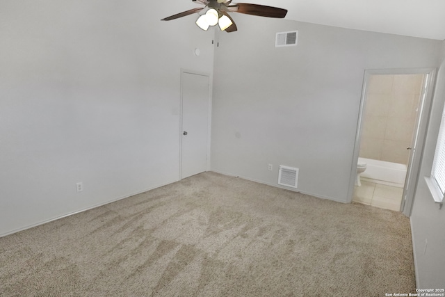 unfurnished room with vaulted ceiling, carpet flooring, visible vents, and a ceiling fan