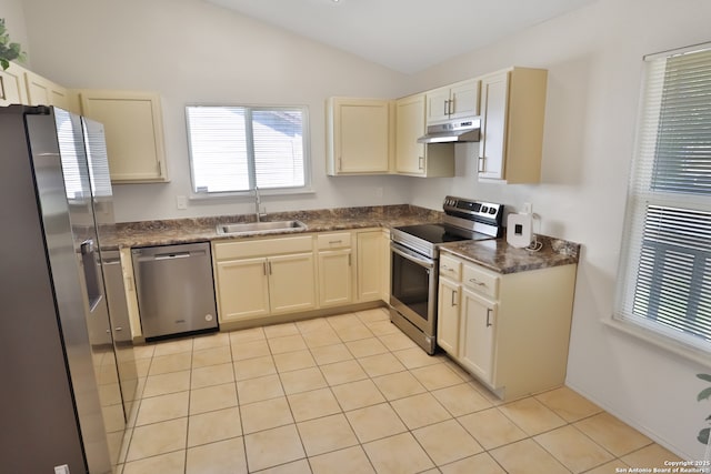 kitchen featuring dark countertops, appliances with stainless steel finishes, vaulted ceiling, under cabinet range hood, and a sink