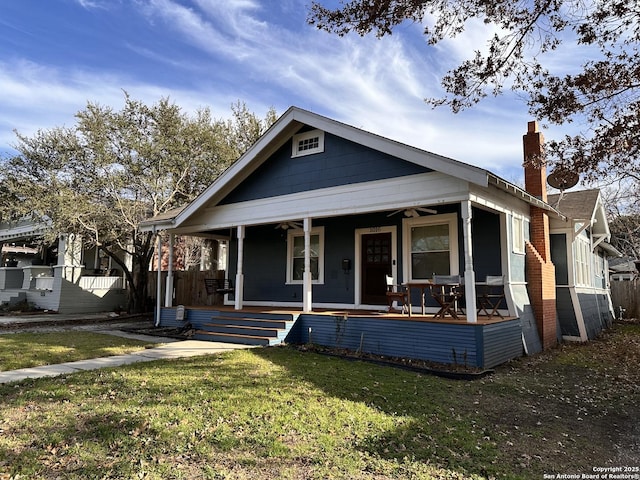 bungalow-style house featuring a porch, fence, and a front lawn