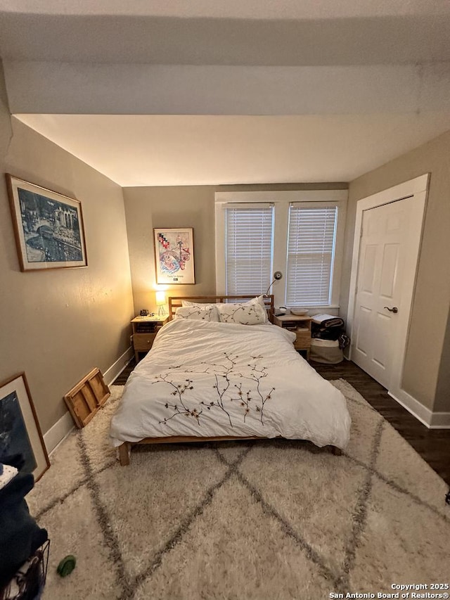 bedroom with baseboards and wood finished floors