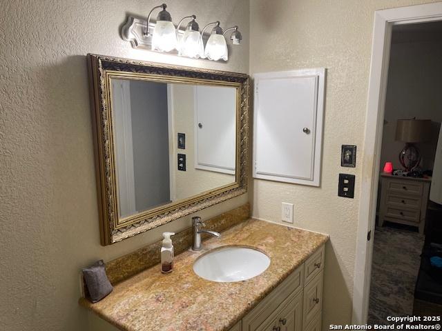 bathroom with vanity and a textured wall