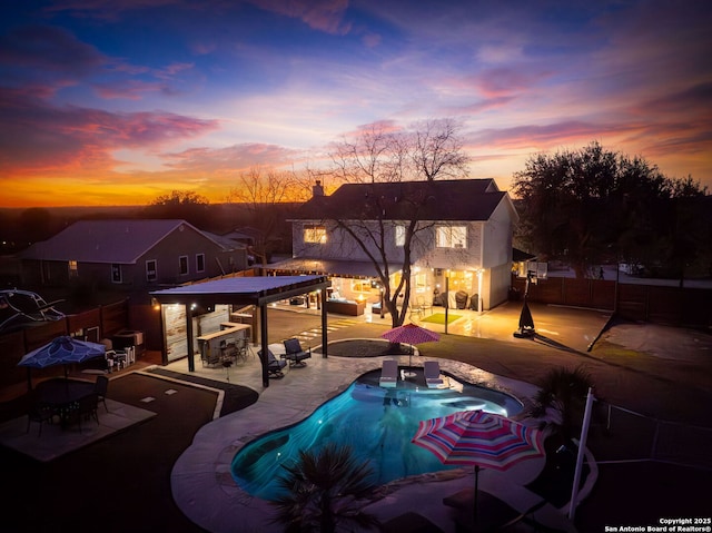 view of swimming pool with outdoor dry bar, a patio area, fence, and a fenced in pool