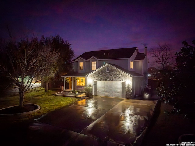 traditional-style home with an attached garage, driveway, and a front lawn