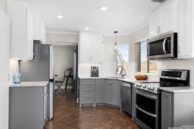 kitchen with stainless steel appliances, gray cabinets, crown molding, and a sink