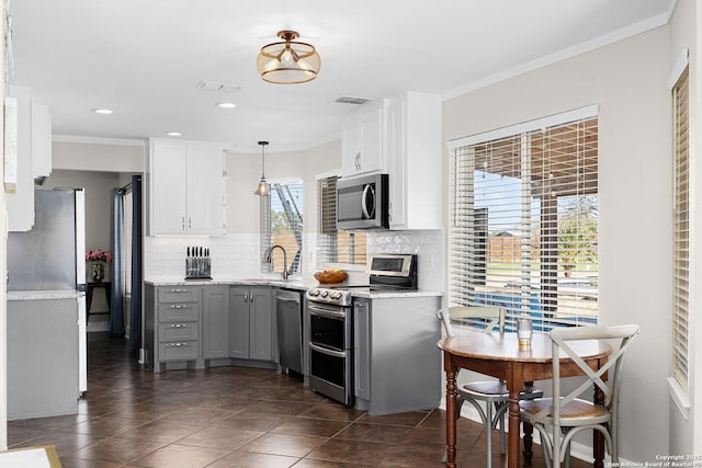 kitchen featuring a sink, appliances with stainless steel finishes, gray cabinets, and crown molding