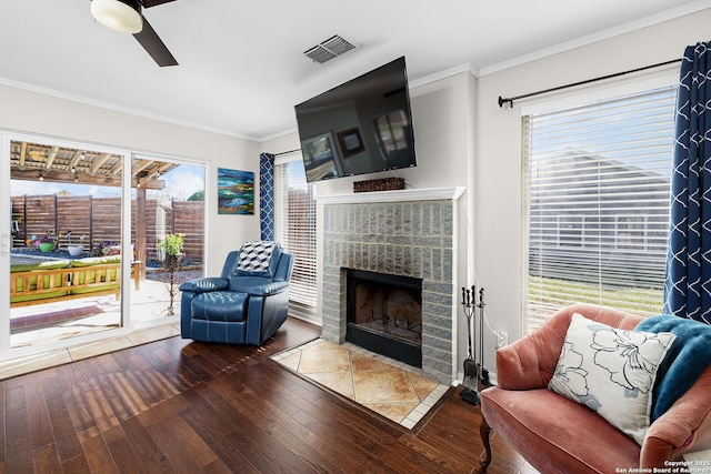 interior space featuring hardwood / wood-style floors, a fireplace, visible vents, and crown molding