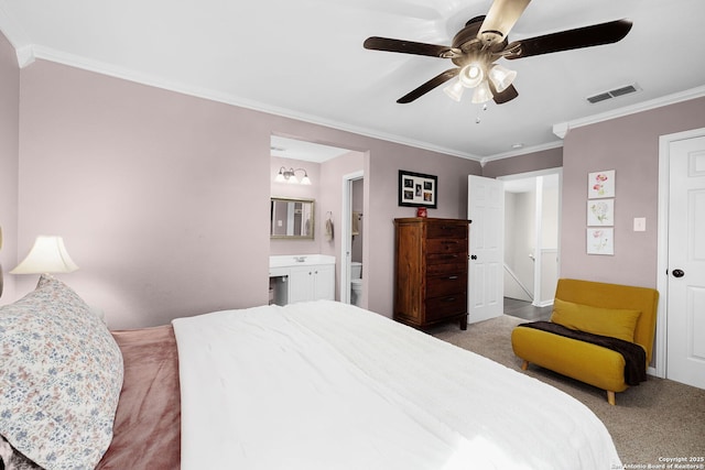 bedroom with a ceiling fan, visible vents, carpet, ensuite bath, and crown molding