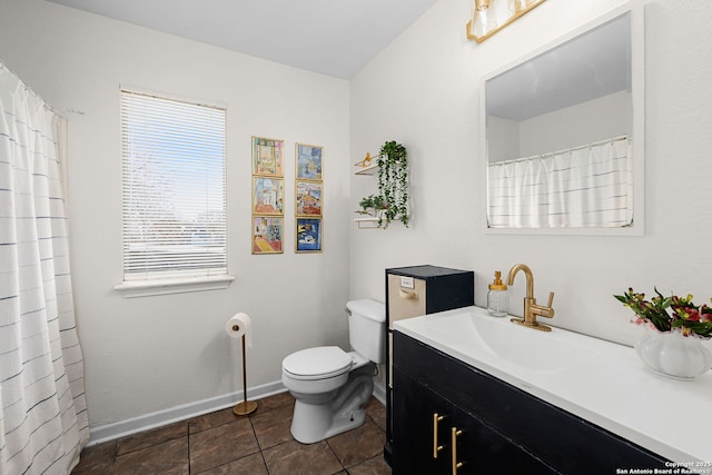 bathroom with toilet, baseboards, and vanity